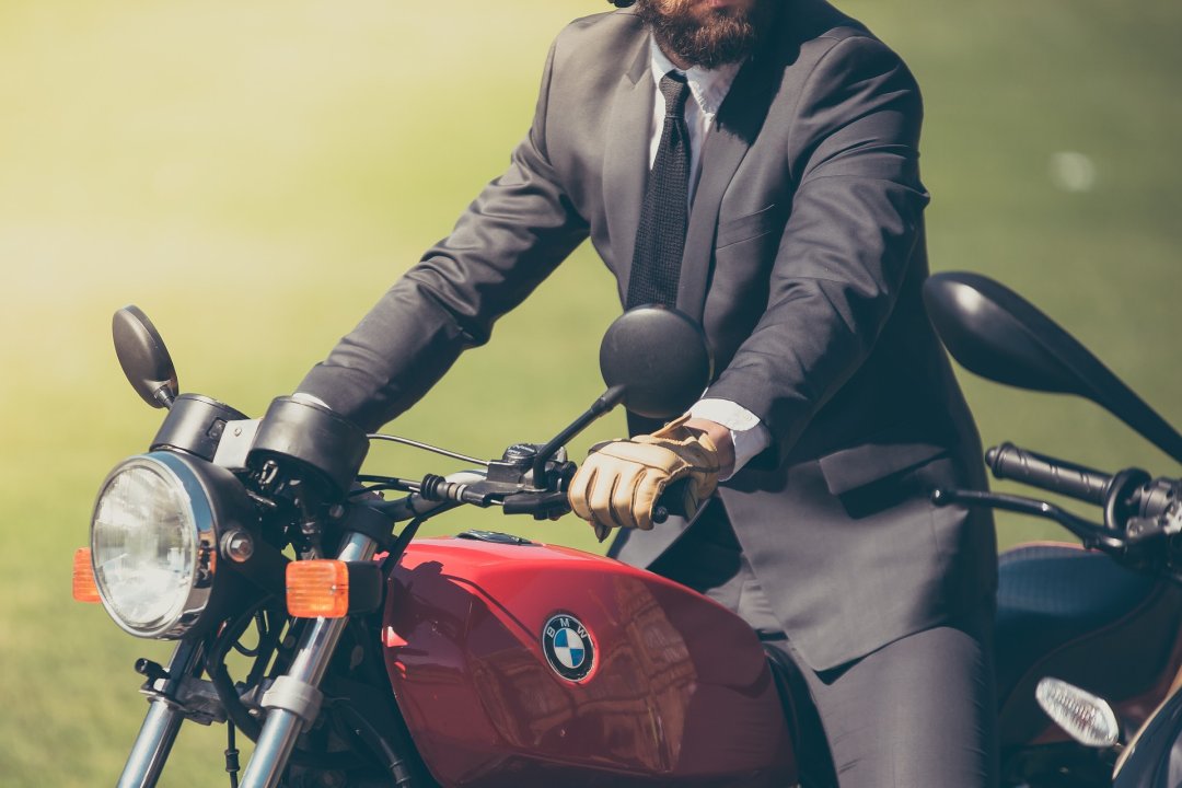 Man in a suit riding a motorcycle