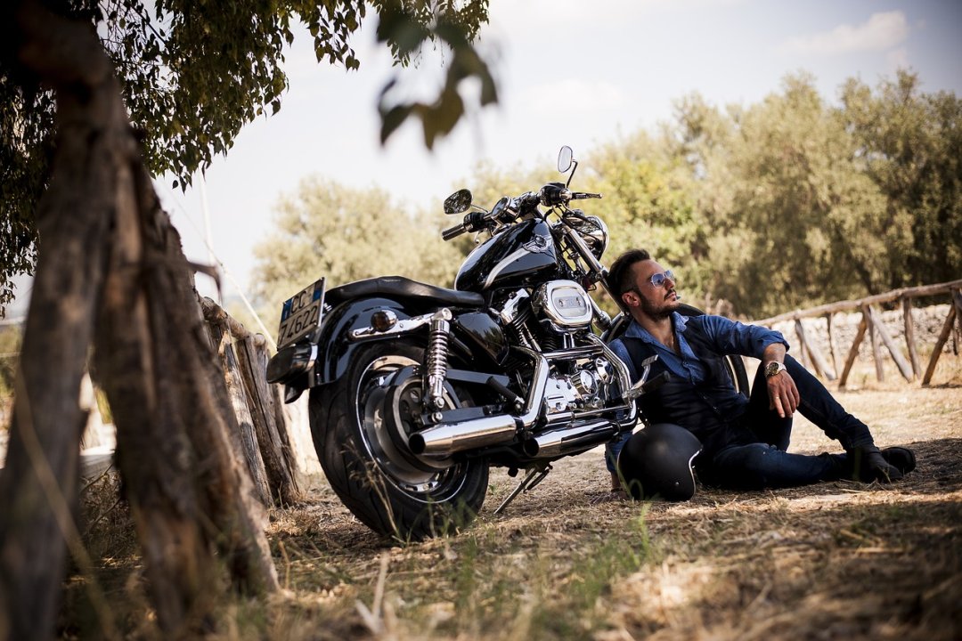 Rider resting next to his motorbike - Best Cruiser Motorcycles for Beginners