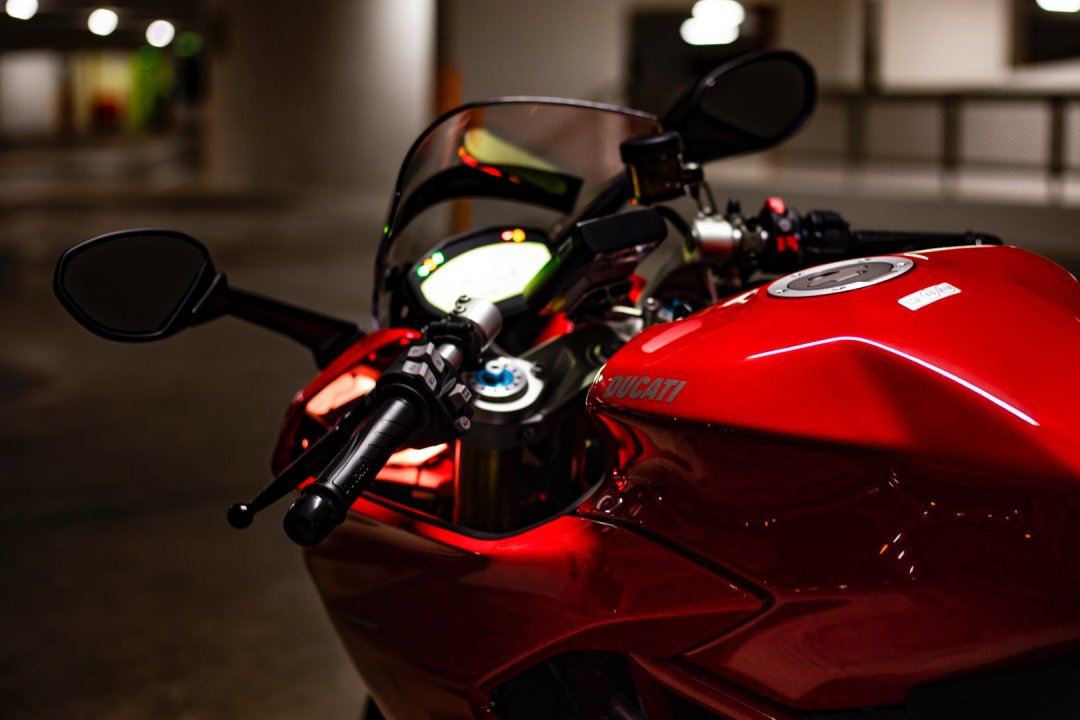 Moto 1000 de couleur rouge garée dans un parking - moto 1000cc