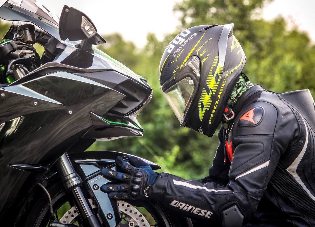 Homme en tenue de motard assis devant une moto de 1000 cm3 - moto 1000cc