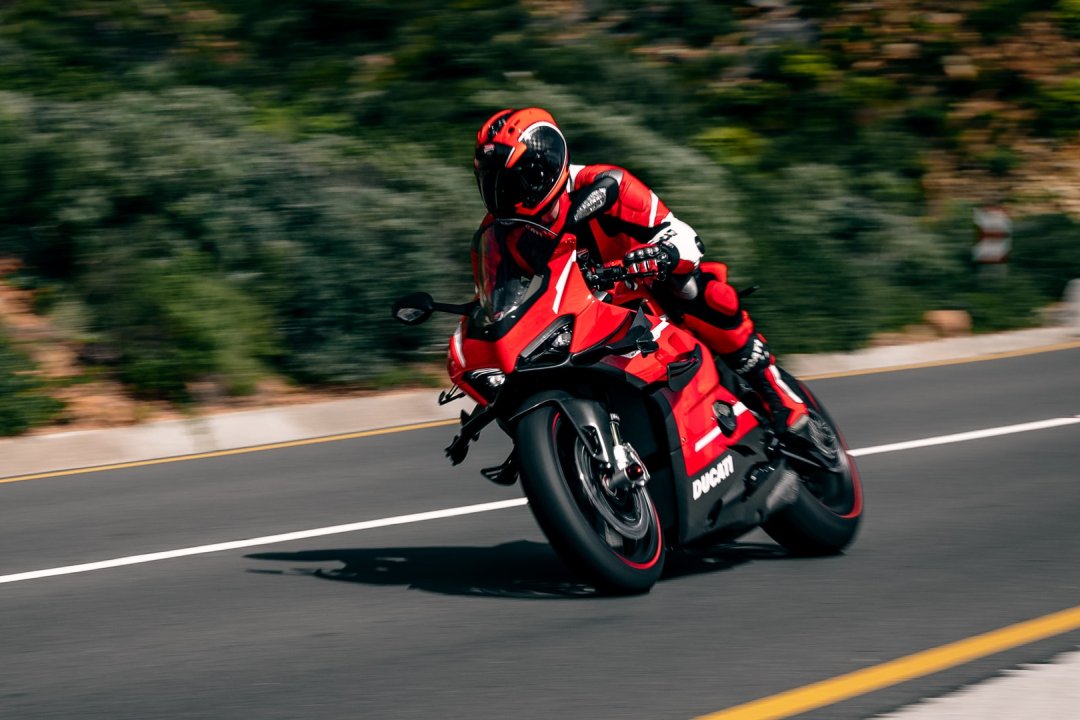 Moto puissante Ducati de couleur rouge et noire pilotée sur une route ouverte - moto la plus rapide du monde