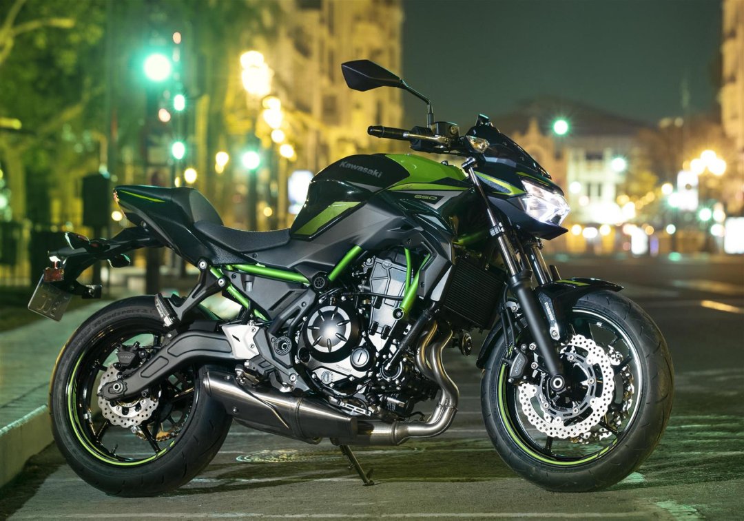 Moto roadster Kawasaki Z 650 2021 noire et verte garée dans la rue de nuit