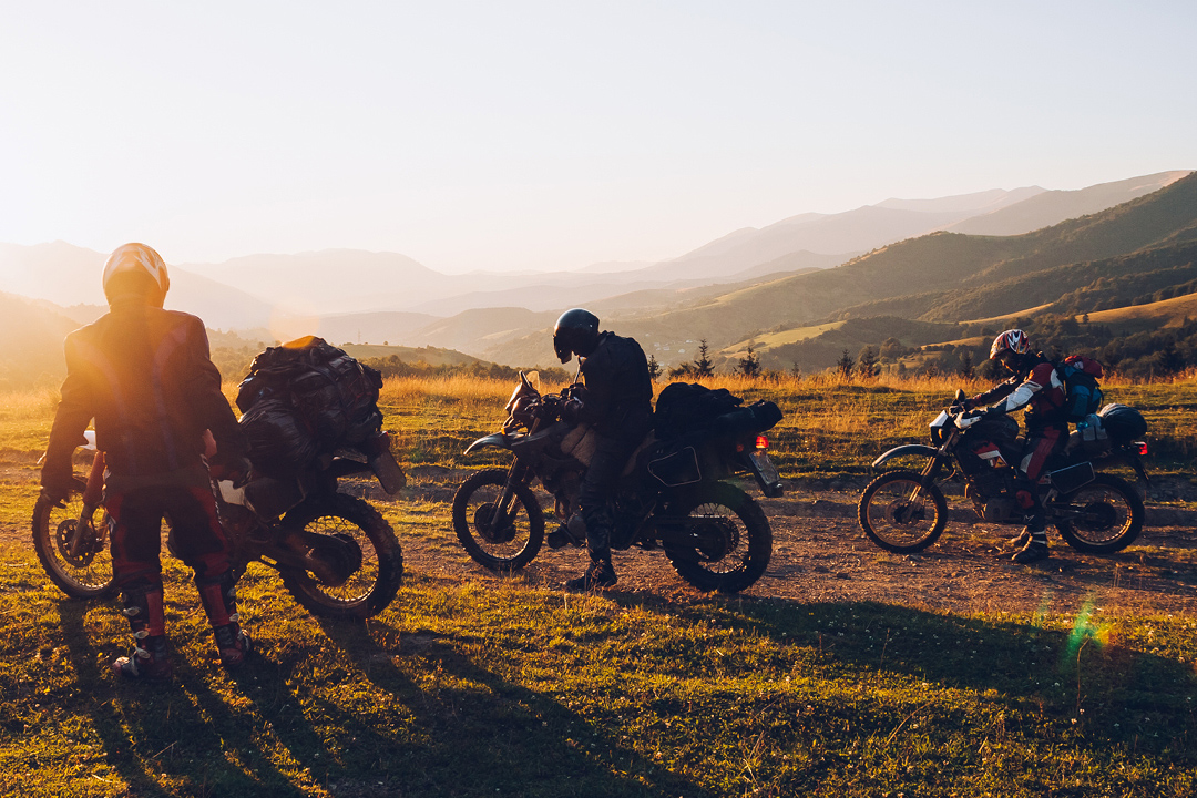 tři enduro jezdci v terénu