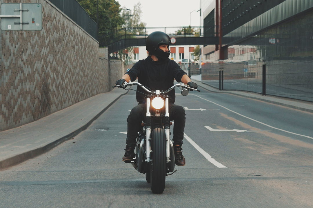 Stylish motorcycle rider riding in the empty street