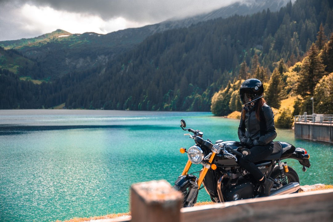 Personne en balade moto au bord d’un lac de montagne - roadtrip moto