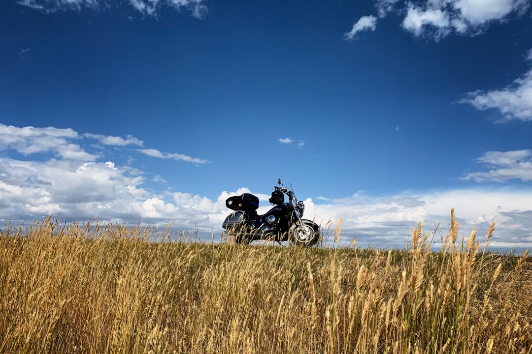 Vacances en moto de couleur noire garée en bord de route - roadtrip moto