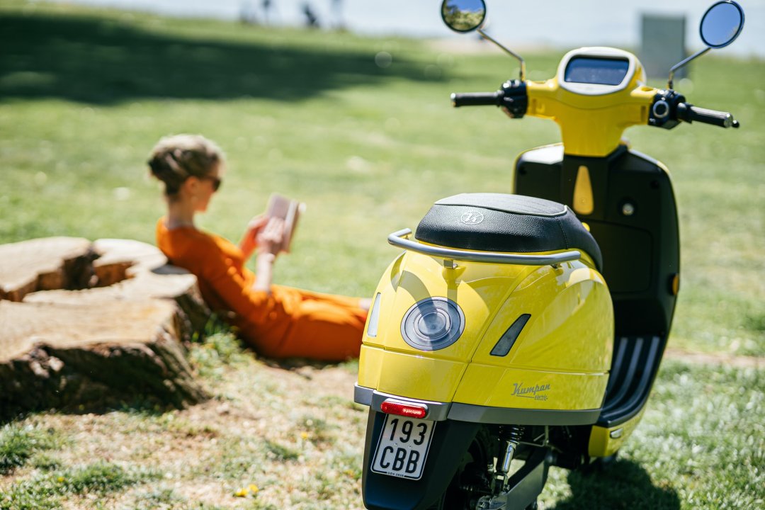 Petit scooter électrique de couleur jaune garé dans un parc